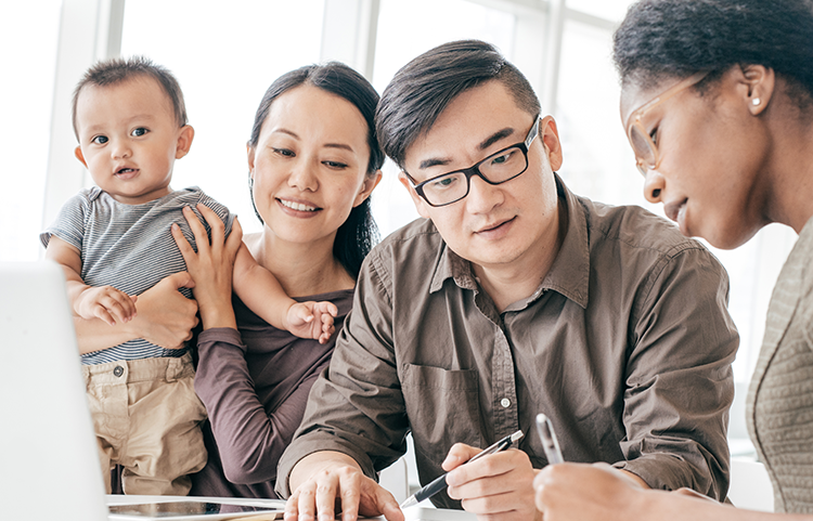 Parents and child sitting at a table with their financial advisor